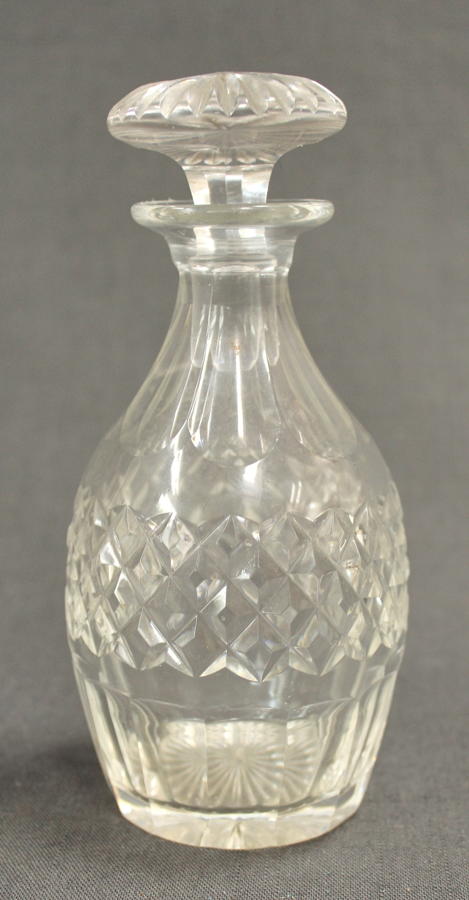 An ovoid clear glass liqueur decanter