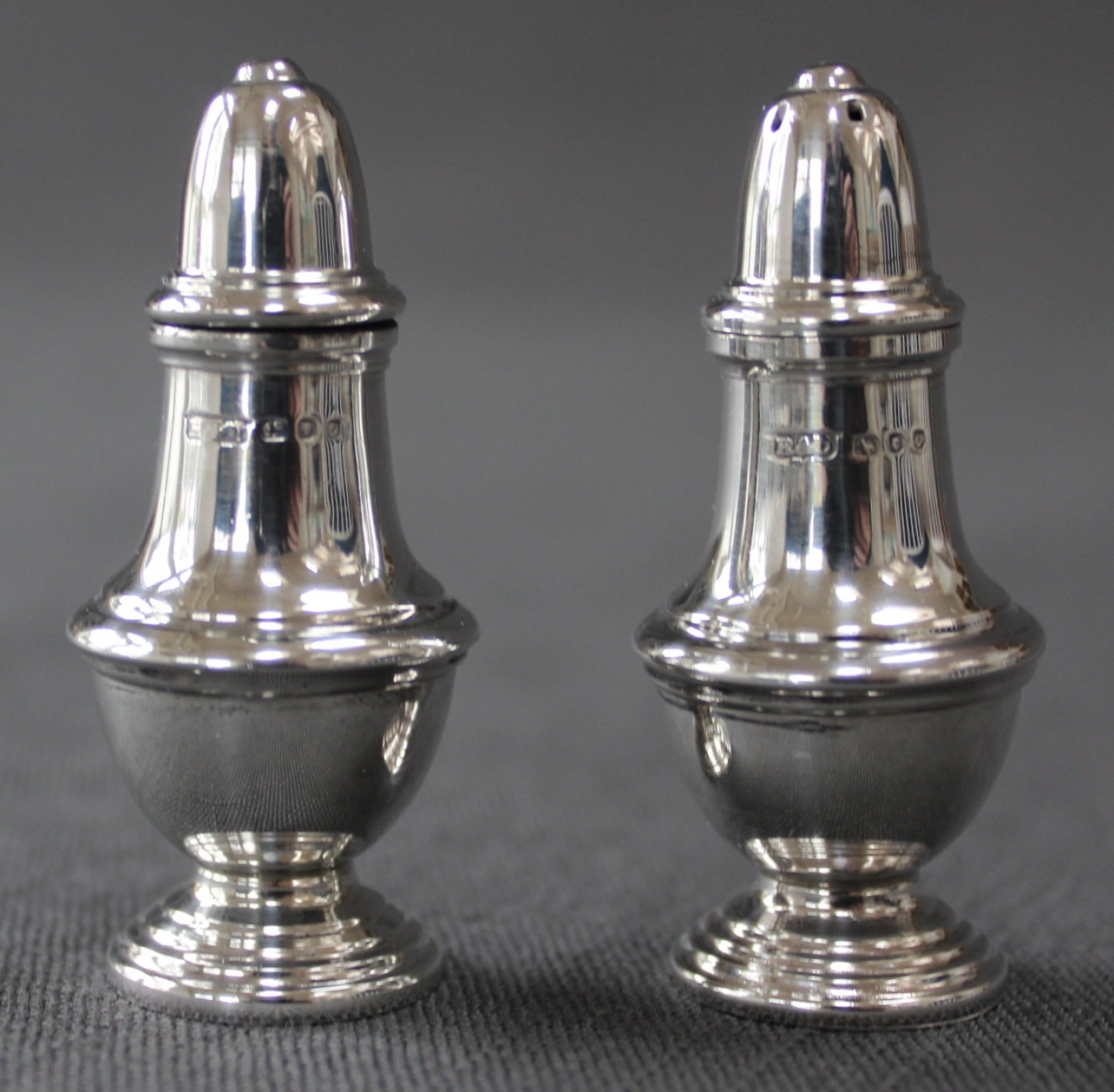 A pair of silver vase shaped cruets